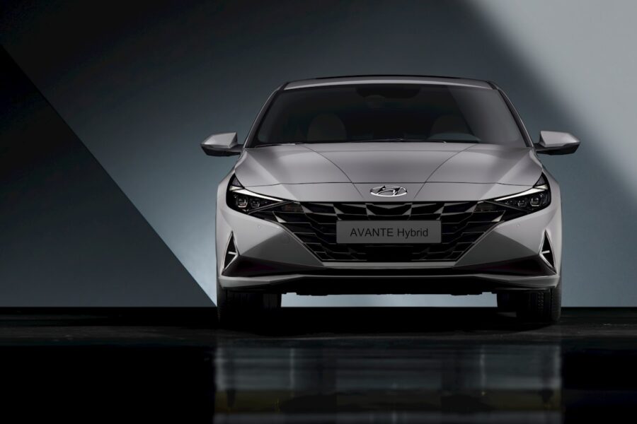 the front end of a silver car in a dark room
