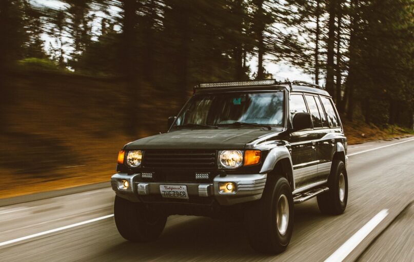 timelapse photography of green SUV on road