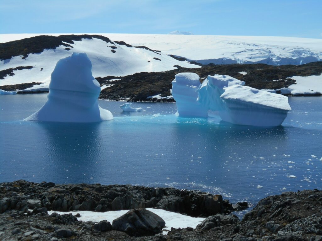 a group of icebergs floating on top of a body of water