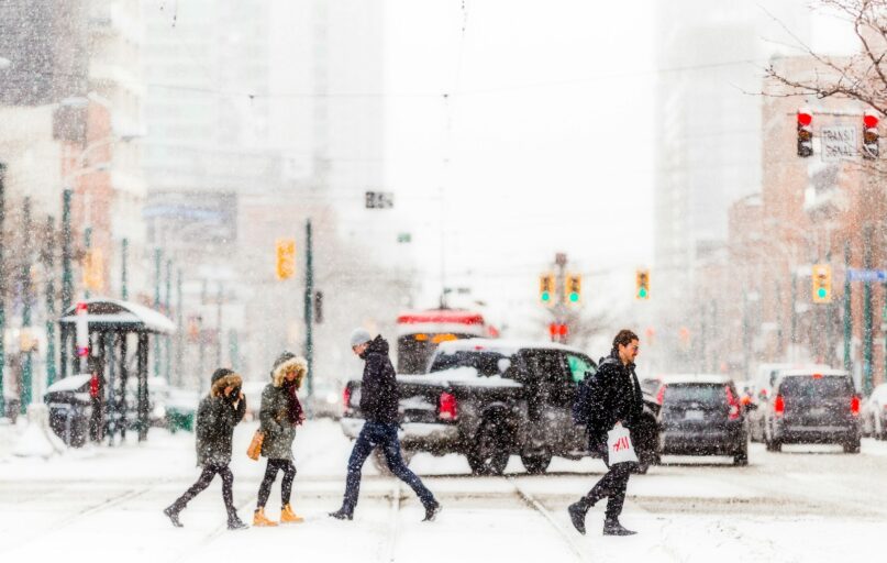 people walking on snow covered road during daytime