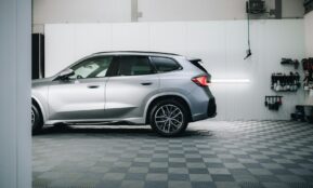 a silver bmw suv parked in a garage