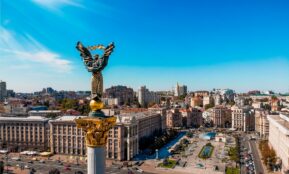 a view of a city with a statue in the middle