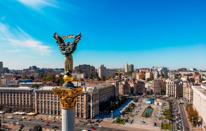 a view of a city with a statue in the middle