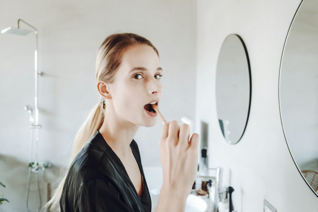 a woman brushing her teeth in front of a mirror