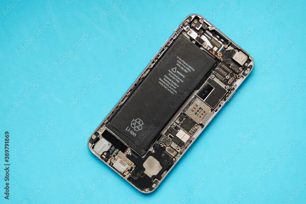 Smartphone motherboard with battery on blue background.