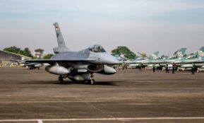 a fighter jet sitting on top of an airport tarmac