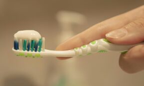 a person is holding a toothbrush with toothpaste on it