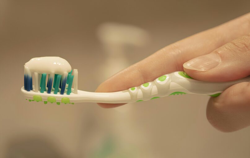 a person is holding a toothbrush with toothpaste on it
