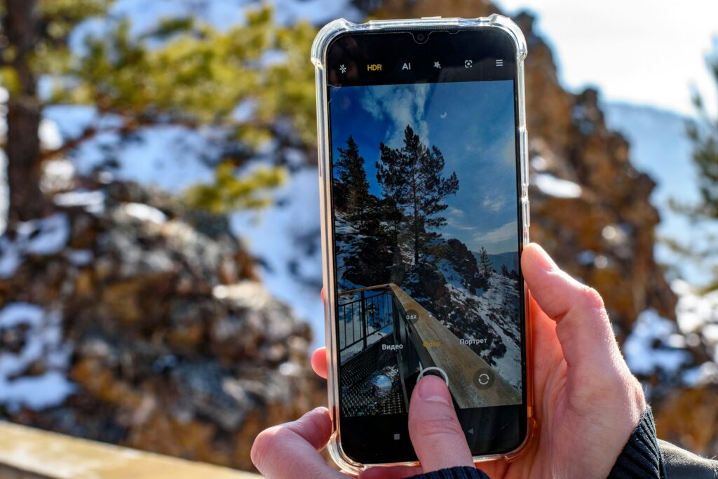 A person taking a picture of a snow covered mountain