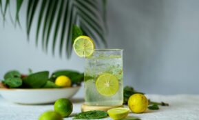 a glass of lemonade with limes and limes