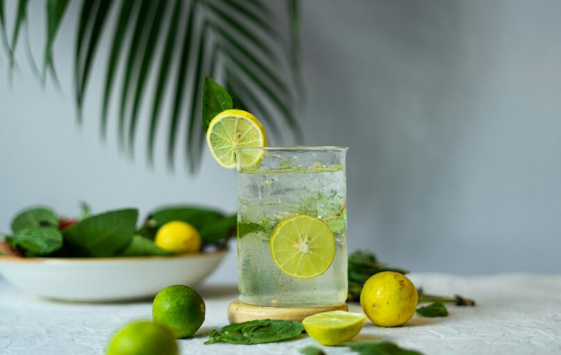 a glass of lemonade with limes and limes