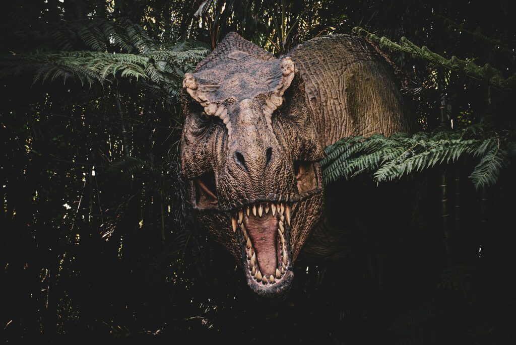 a large dinosaur with its mouth open in a forest