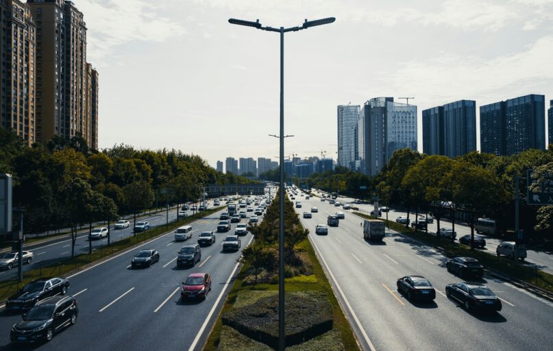 a city street filled with lots of traffic next to tall buildings