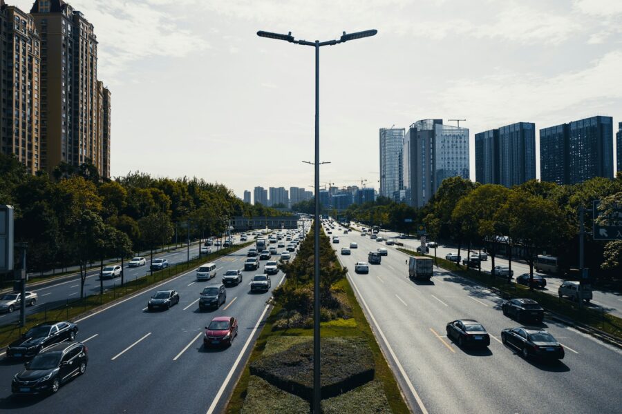 a city street filled with lots of traffic next to tall buildings