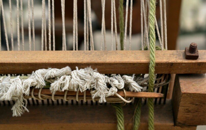 Close-up of a wooden loom with threads