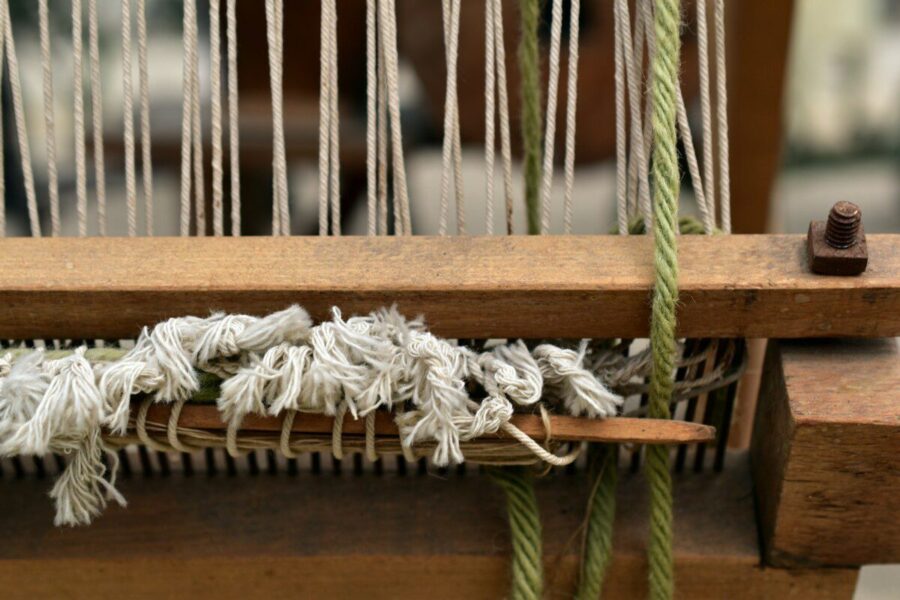 Close-up of a wooden loom with threads