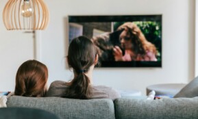 a couple of women sitting on top of a couch