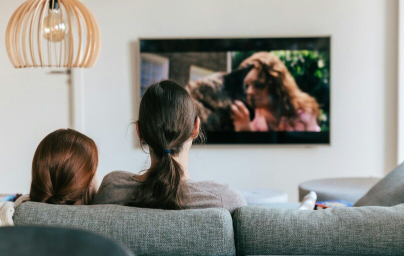 a couple of women sitting on top of a couch