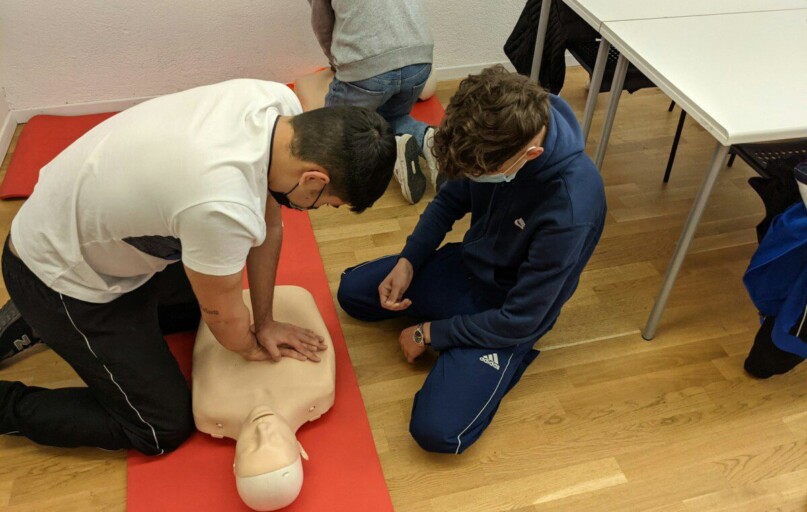 man in white t-shirt and blue pants sitting on floor