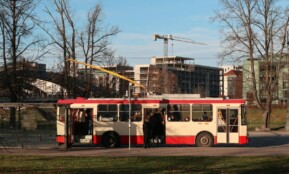 a red and white bus driving down a street