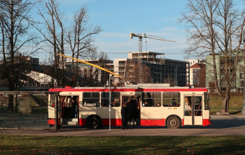 a red and white bus driving down a street