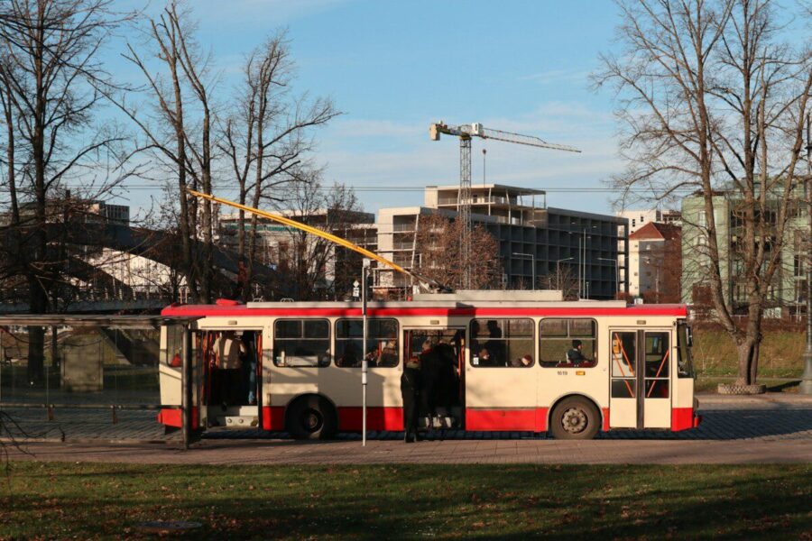 a red and white bus driving down a street