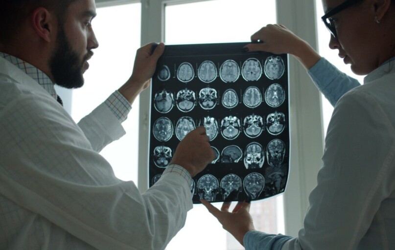 Two doctors examining a brain mri scan together.