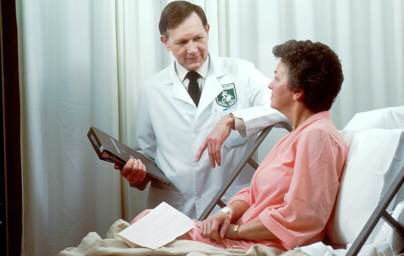 man in white button up shirt holding black tablet computer