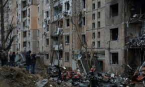 a group of people standing in front of a pile of rubble