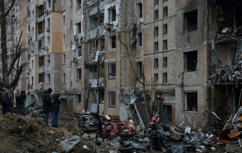 a group of people standing in front of a pile of rubble