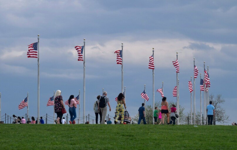 a group of people standing on top of a lush green field