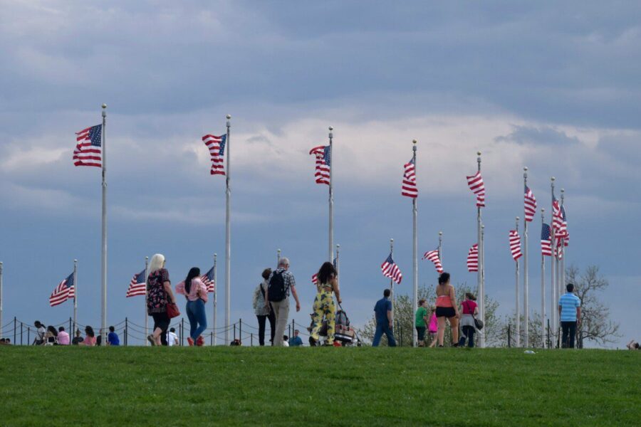a group of people standing on top of a lush green field