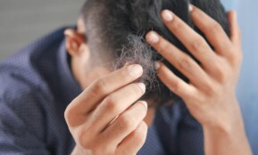 a man is combing his hair with his hands