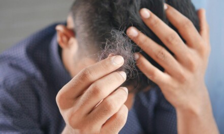 a man is combing his hair with his hands