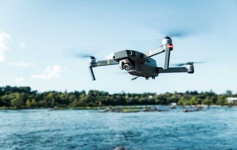 black DJI Mavi quadcopter near body of water