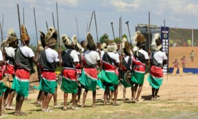 Warriors in traditional attire with spears