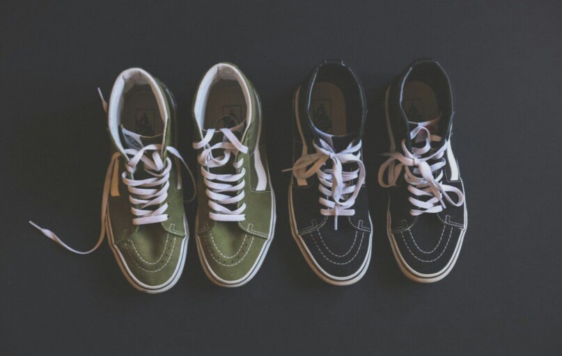 two pairs of black green-and-black Vans Sk8-Hi sneakers