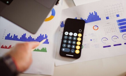 a calculator sitting on top of a table next to a laptop