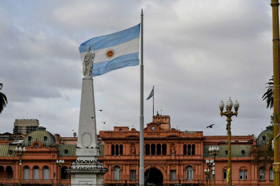 Argentinian flag waving near a prominent building.