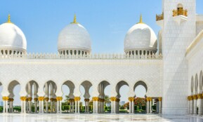 A large white building with many arches and domes