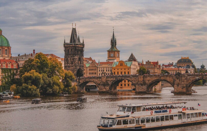 white and brown boat on river near brown concrete building during daytime