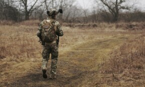 man walking on brown grass field