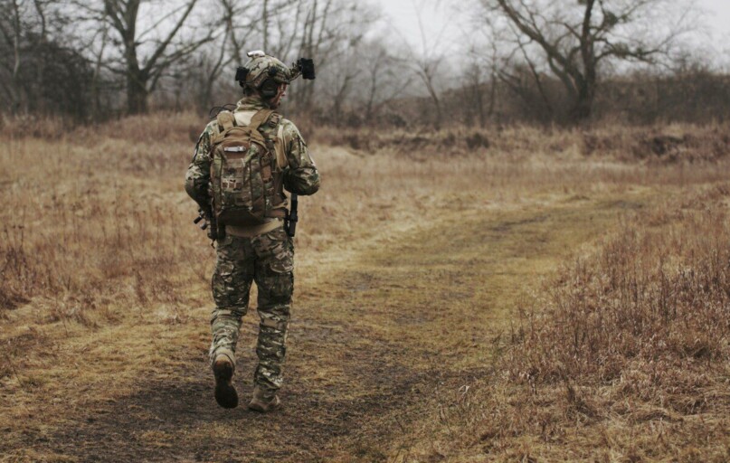 man walking on brown grass field