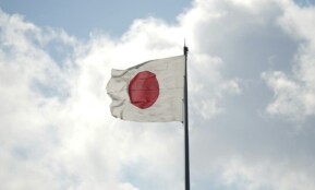 a white and red flag flying in the sky