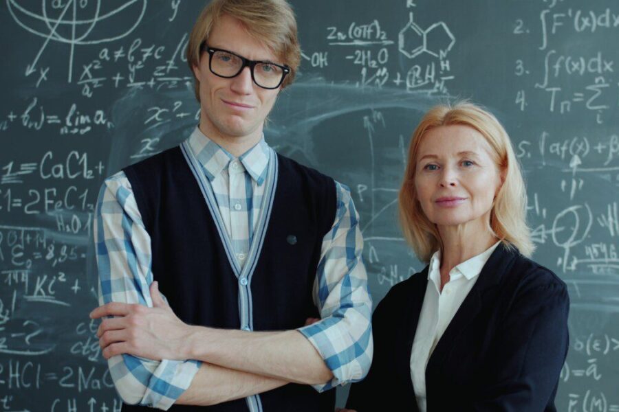 A young man and older woman in front of chalkboard.