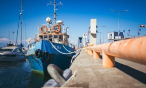a blue and white boat docked at a pier