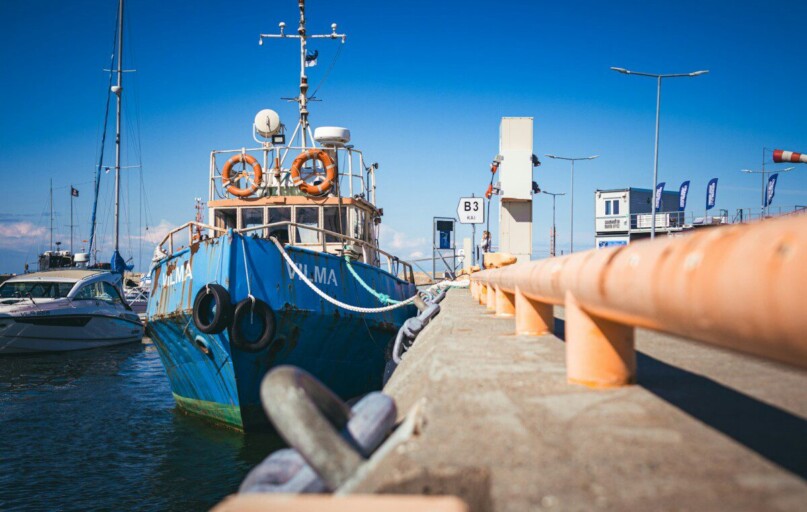 a blue and white boat docked at a pier