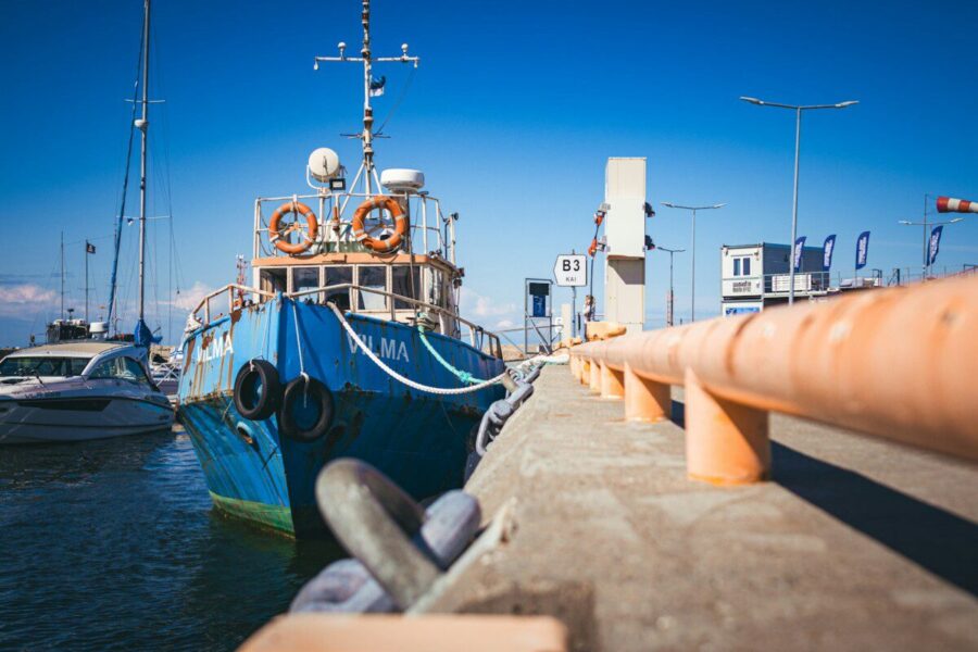 a blue and white boat docked at a pier