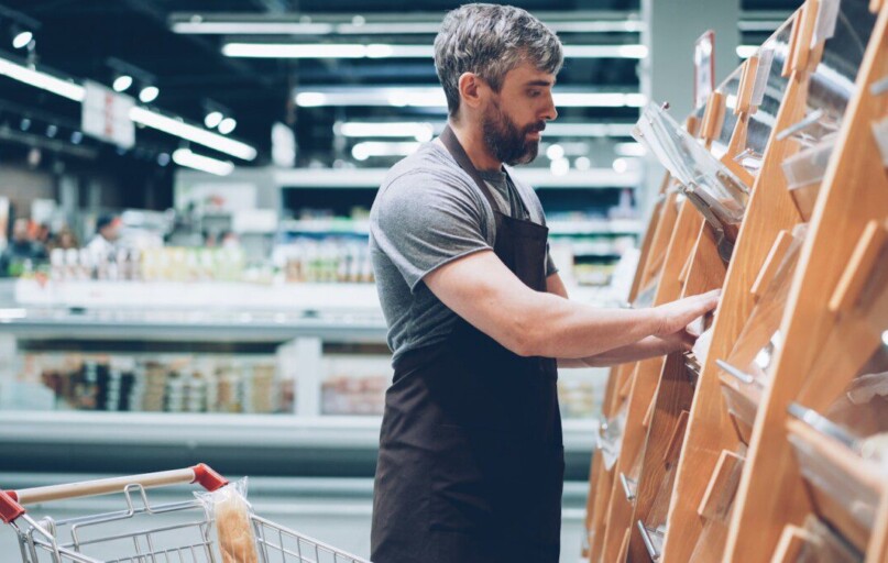 A man sorts items in a grocery store.