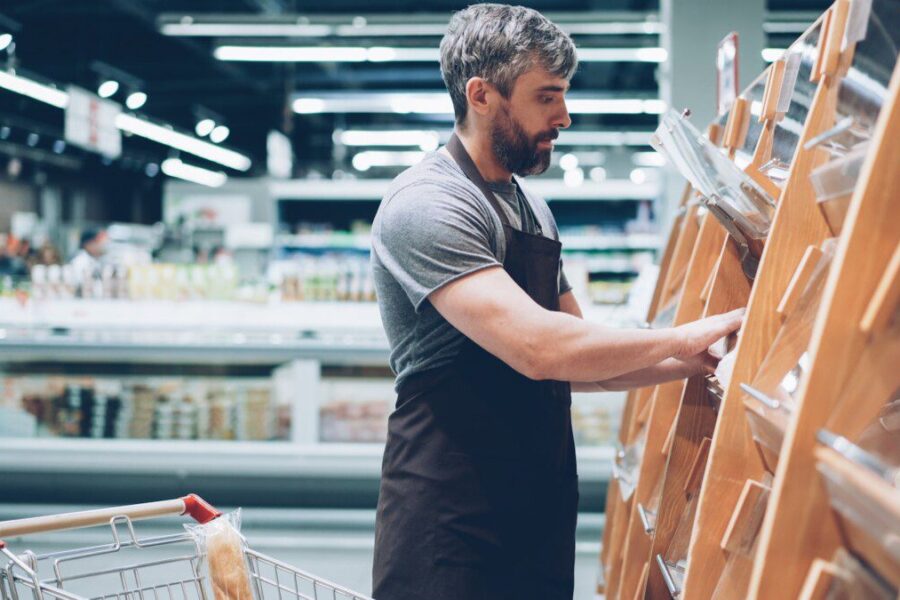 A man sorts items in a grocery store.